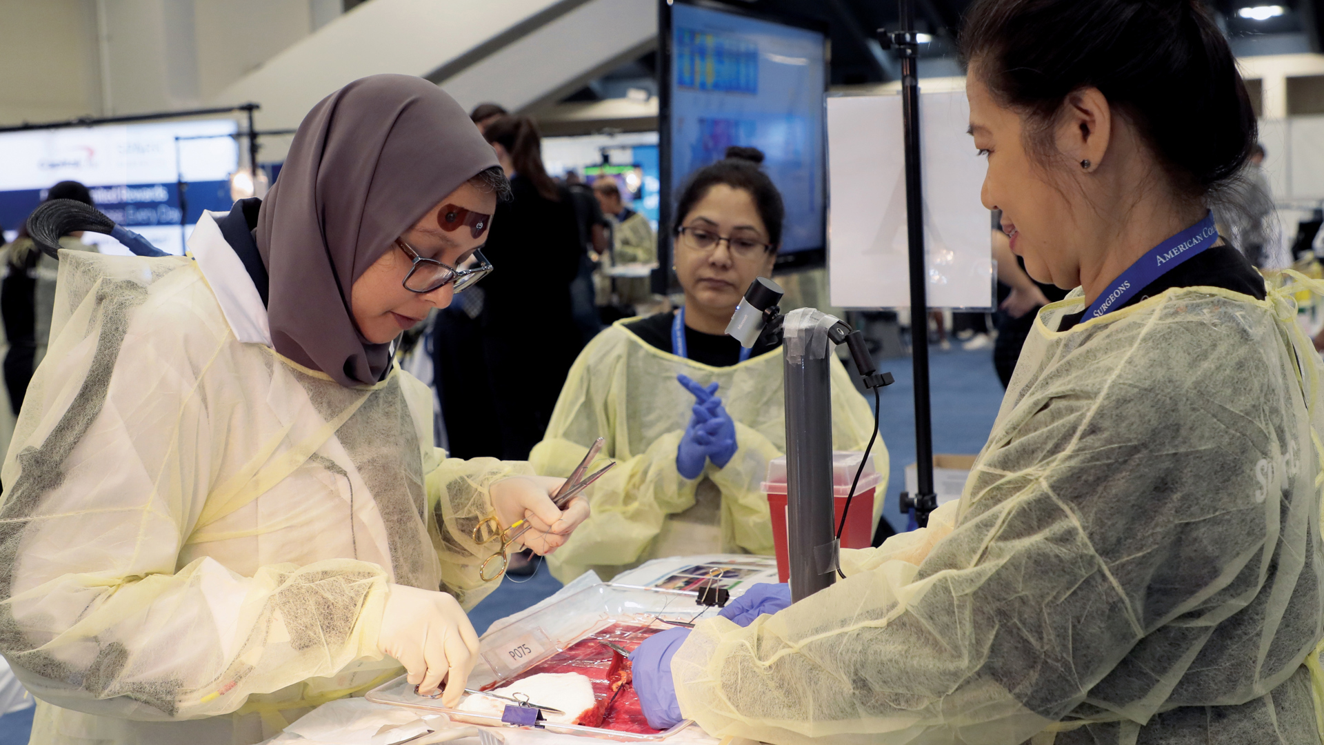 A Clinical Congress attendee takes part in a Surgical Metrics Project simulation while wearing a forehead EEG sensor.