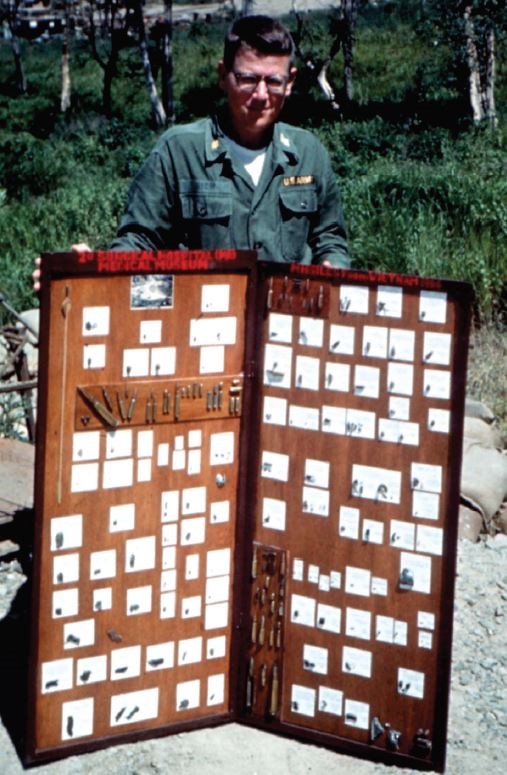 Dr. Rich as a young surgeon in Vietnam in 1966, displaying wounding objects